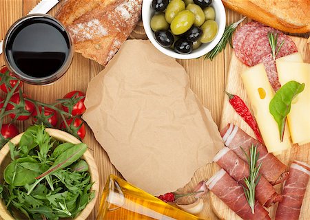 simsearch:400-07481826,k - Red wine with cheese, olives, tomatoes, prosciutto, bread and spices. Over wooden table background. View from above with copy space Stock Photo - Budget Royalty-Free & Subscription, Code: 400-07481821