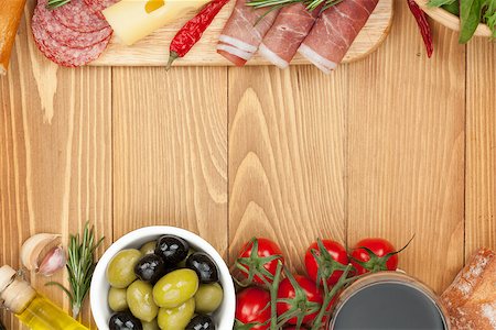 simsearch:400-07481826,k - Red wine with cheese, olives, tomatoes, prosciutto, bread and spices. Over wooden table background. View from above with copy space Stock Photo - Budget Royalty-Free & Subscription, Code: 400-07481822