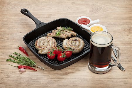 simsearch:695-05773485,k - Grilled sausages with ketchup, mustard and mug of beer. Over wooden table background Foto de stock - Royalty-Free Super Valor e Assinatura, Número: 400-07481860