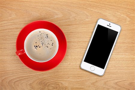 Mobile phone and coffee cup on office wooden table Stock Photo - Budget Royalty-Free & Subscription, Code: 400-07481876