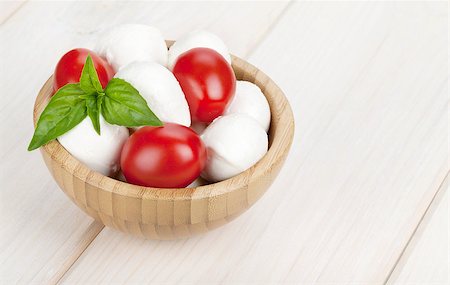 simsearch:400-08071423,k - Mozzarella cheese with cherry tomatoes and basil on white wood table Foto de stock - Royalty-Free Super Valor e Assinatura, Número: 400-07481943
