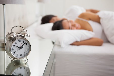 simsearch:400-07483522,k - Couple lying in bed with focus on alarm clock at home in bedroom Stock Photo - Budget Royalty-Free & Subscription, Code: 400-07483059