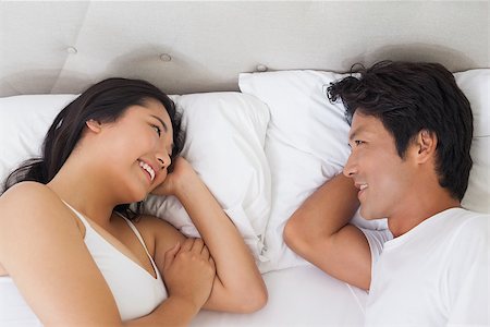 simsearch:400-07483522,k - Happy couple lying in bed chatting at home in bedroom Stock Photo - Budget Royalty-Free & Subscription, Code: 400-07483062
