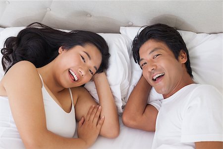 simsearch:400-07483522,k - Happy couple lying in bed smiling at camera at home in bedroom Stock Photo - Budget Royalty-Free & Subscription, Code: 400-07483063