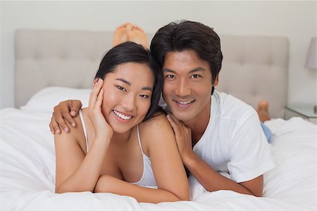 simsearch:400-07483522,k - Happy couple lying on bed at home in bedroom Stock Photo - Budget Royalty-Free & Subscription, Code: 400-07483094