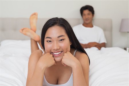 simsearch:400-07483522,k - Woman lying on bed smiling at camera at home in bedroom Stock Photo - Budget Royalty-Free & Subscription, Code: 400-07483091