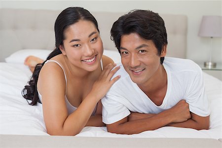 simsearch:400-07483522,k - Happy couple lying on bed together at home in bedroom Stock Photo - Budget Royalty-Free & Subscription, Code: 400-07483104