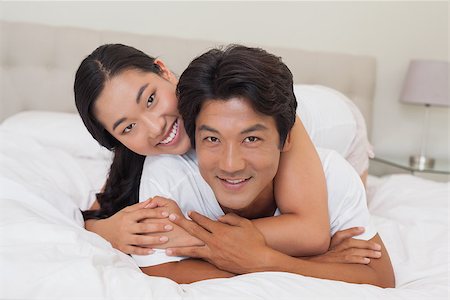 simsearch:400-07483522,k - Happy couple lying on bed together at home in bedroom Stock Photo - Budget Royalty-Free & Subscription, Code: 400-07483108