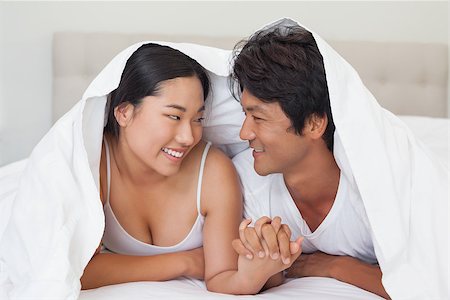 simsearch:400-07483522,k - Happy couple lying on bed together under the duvet at home in bedroom Stock Photo - Budget Royalty-Free & Subscription, Code: 400-07483117