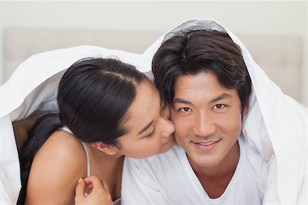 simsearch:400-07483522,k - Happy couple lying on bed together under the duvet at home in bedroom Stock Photo - Budget Royalty-Free & Subscription, Code: 400-07483119