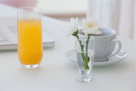White flower in a vase with coffee and orange juice on table at home in the living room Stock Photo - Budget Royalty-Free & Subscription, Code: 400-07483175