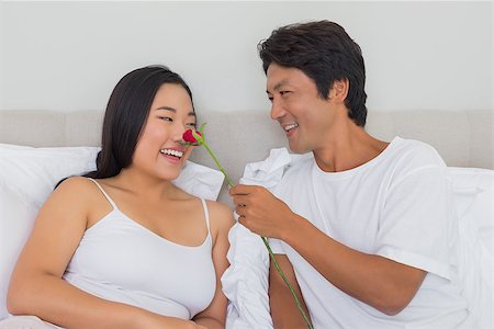 simsearch:400-07483522,k - Man touching his girlfriends nose with red rose at home in bedroom Stock Photo - Budget Royalty-Free & Subscription, Code: 400-07483207