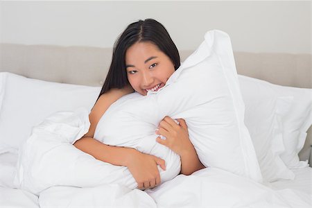 simsearch:400-07483522,k - Smiling woman hugging her pillow at home in bedroom Stock Photo - Budget Royalty-Free & Subscription, Code: 400-07483234