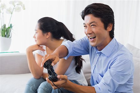 simsearch:400-07483384,k - Woman being ignored by boyfriend playing video games at home in the living room Stock Photo - Budget Royalty-Free & Subscription, Code: 400-07483270