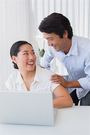 simsearch:400-07483384,k - Happy couple using laptop together at home in the living room Stock Photo - Budget Royalty-Free & Subscription, Code: 400-07483357