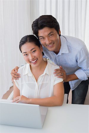 simsearch:400-07483384,k - Happy couple using laptop together at home in the living room Stock Photo - Budget Royalty-Free & Subscription, Code: 400-07483359