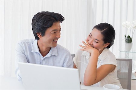 simsearch:400-07483384,k - Happy couple using laptop together at home in the living room Stock Photo - Budget Royalty-Free & Subscription, Code: 400-07483364