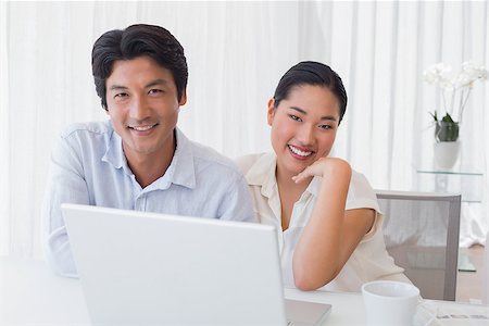 simsearch:400-07483384,k - Happy couple using laptop together at home in the living room Stock Photo - Budget Royalty-Free & Subscription, Code: 400-07483365