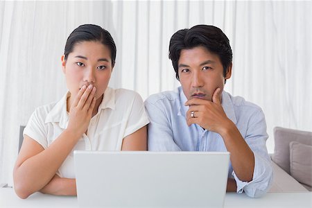 simsearch:400-07483384,k - Worried couple using laptop together at home in the living room Stock Photo - Budget Royalty-Free & Subscription, Code: 400-07483369