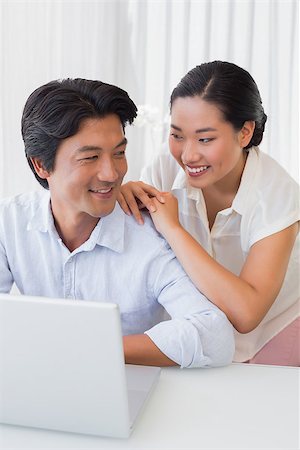 simsearch:400-07483384,k - Happy couple using laptop together at home in the living room Stock Photo - Budget Royalty-Free & Subscription, Code: 400-07483361