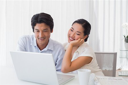 simsearch:400-07483384,k - Happy couple using laptop together at home in the living room Stock Photo - Budget Royalty-Free & Subscription, Code: 400-07483362