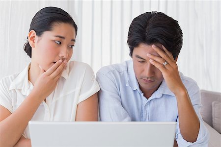 simsearch:400-07483384,k - Worried couple using laptop together at home in the living room Stock Photo - Budget Royalty-Free & Subscription, Code: 400-07483370