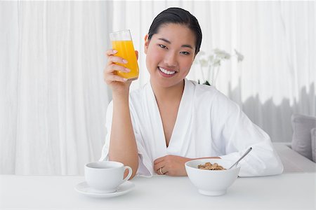 simsearch:400-07483384,k - Happy woman in bathrobe having her breakfast at home in the living room Stock Photo - Budget Royalty-Free & Subscription, Code: 400-07483389