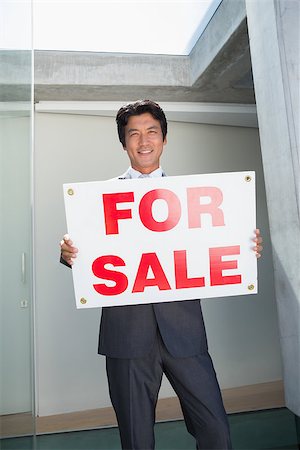 simsearch:400-07475963,k - Confident estate agent standing at front door showing for sale sign outside a house Stock Photo - Budget Royalty-Free & Subscription, Code: 400-07483414