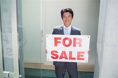 simsearch:400-07475963,k - Confident estate agent standing at front door showing for sale sign outside a house Stock Photo - Budget Royalty-Free & Subscription, Code: 400-07483412