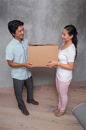 simsearch:400-07928013,k - Happy couple holding a cardboard moving box in their new home Fotografie stock - Microstock e Abbonamento, Codice: 400-07483491