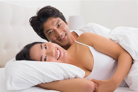 simsearch:400-07483522,k - Smiling couple lying in bed at home in bedroom Stock Photo - Budget Royalty-Free & Subscription, Code: 400-07483524