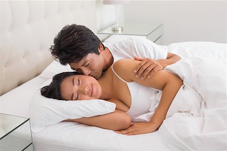 simsearch:400-07483522,k - Man kissing his girlfriend on the cheek in bed at home in bedroom Stock Photo - Budget Royalty-Free & Subscription, Code: 400-07483525