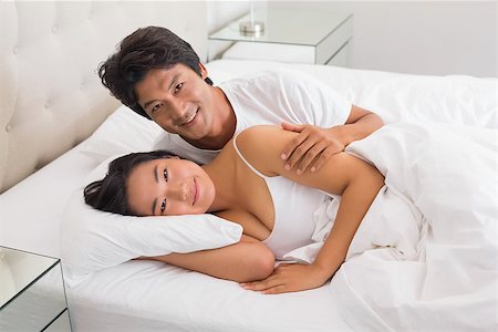 simsearch:400-07483522,k - Smiling couple lying in bed at home in bedroom Stock Photo - Budget Royalty-Free & Subscription, Code: 400-07483526