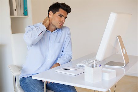 Casual businessman touching his sore neck in his office Stock Photo - Budget Royalty-Free & Subscription, Code: 400-07483624