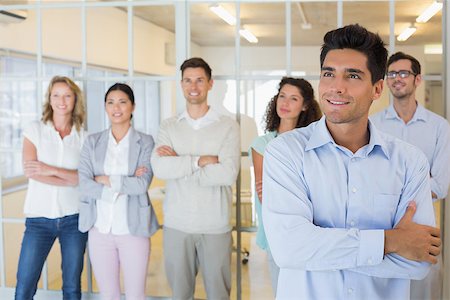 simsearch:400-07186359,k - Casual boss smiling with arms crossed in front of business team in the office Stock Photo - Budget Royalty-Free & Subscription, Code: 400-07483917