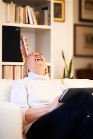 portrait of beautiful old woman using tablet pc and smiling, sitting on sofa at home Stock Photo - Budget Royalty-Free & Subscription, Code: 400-07498947