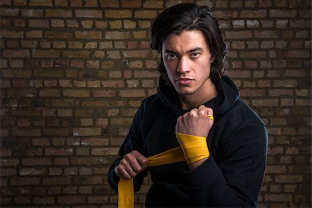 Young Malaysian boxer  wearing hoodie and wrapping straps around hands Stock Photo - Budget Royalty-Free & Subscription, Code: 400-07499872