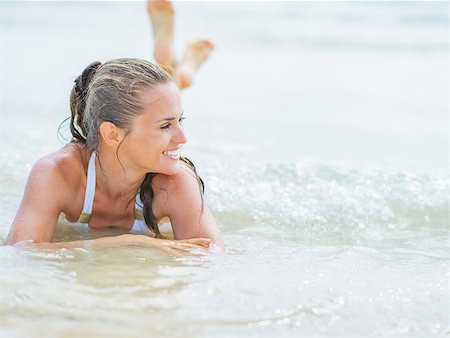 simsearch:400-06207710,k - Happy young woman in swimsuit laying on sea coast Foto de stock - Super Valor sin royalties y Suscripción, Código: 400-07504146