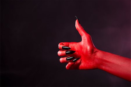 evil hand - Spooky red devil hand with black nails showing thumbs up, studio shot on smoky background Stock Photo - Budget Royalty-Free & Subscription, Code: 400-07505719