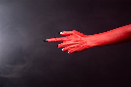 simsearch:400-04680939,k - Red devil pointing hand with black sharp nails, extreme body-art, Halloween theme Fotografie stock - Microstock e Abbonamento, Codice: 400-07505720