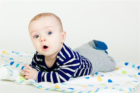 simsearch:400-07506232,k - Portrait of a cute baby in striped clothes lying down on a blanket Stock Photo - Budget Royalty-Free & Subscription, Code: 400-07506226