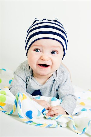 simsearch:400-07506232,k - Portrait of a cute baby in striped hat lying down on a blanket Stock Photo - Budget Royalty-Free & Subscription, Code: 400-07506231