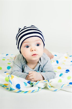 simsearch:400-07506232,k - Portrait of a cute baby in striped hat lying down on a blanket Stock Photo - Budget Royalty-Free & Subscription, Code: 400-07506233