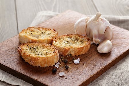 pan de ajo - crostini with olive oil and garlic, on cutting board Foto de stock - Super Valor sin royalties y Suscripción, Código: 400-07506496