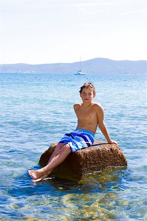simsearch:400-06794010,k - Cute eleven years old boy sitting on a rock in the sea Stock Photo - Budget Royalty-Free & Subscription, Code: 400-07507027