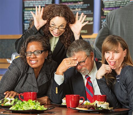 simsearch:400-06561343,k - Embarrassed man with coworkers making faces in cafe Stock Photo - Budget Royalty-Free & Subscription, Code: 400-07507043