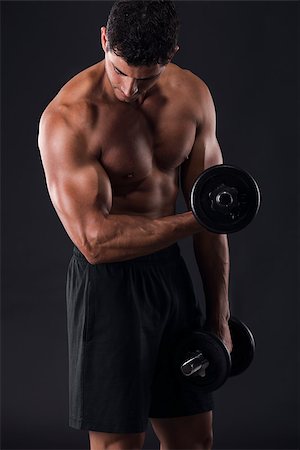 Portrait of a muscular man lifting weights against a dark background Stock Photo - Budget Royalty-Free & Subscription, Code: 400-07507534