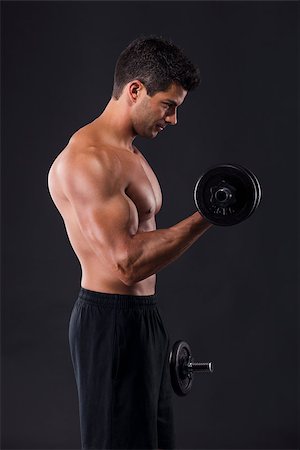 Portrait of a muscular man lifting weights against a dark background Stock Photo - Budget Royalty-Free & Subscription, Code: 400-07507532