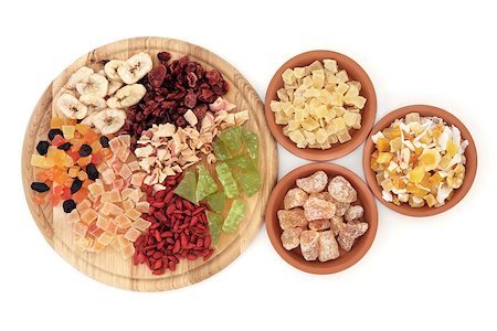 simsearch:400-08618279,k - Dried fruit selection on a wooden board and in terracotta bowls over white background. Photographie de stock - Aubaine LD & Abonnement, Code: 400-07507650