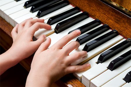 Llittle girl trying to play the piano with her little fingers. Stock Photo - Budget Royalty-Free & Subscription, Code: 400-07507676